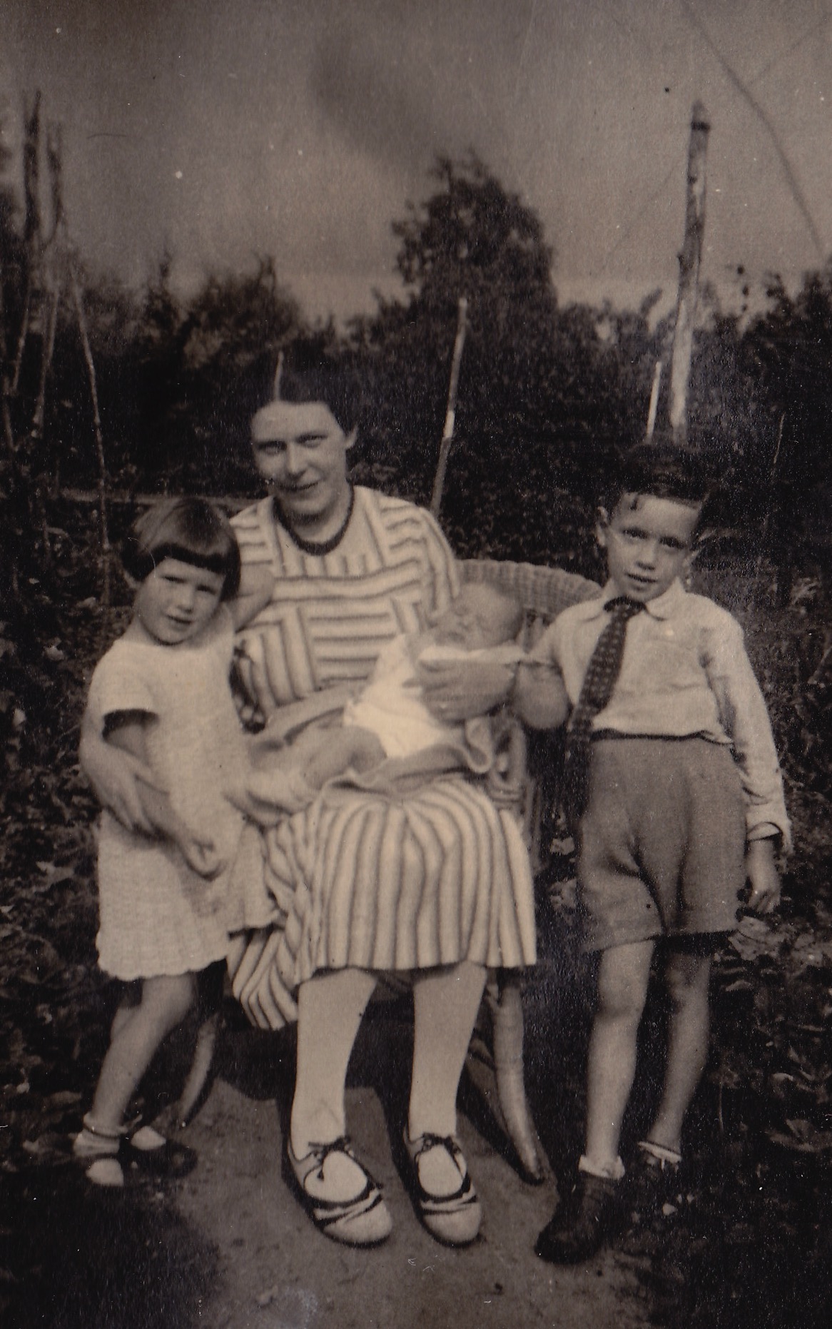 Klaaswaal, 1937. In de moestuin van de pastorie. vlnr mijn tante Margreth (1934-2022), oma Hugenholtz-Lehmkuhl, op schoot, de pasgeboren Albert en daarnaast mijn vader Hans Hugenholtz (1932-2018).